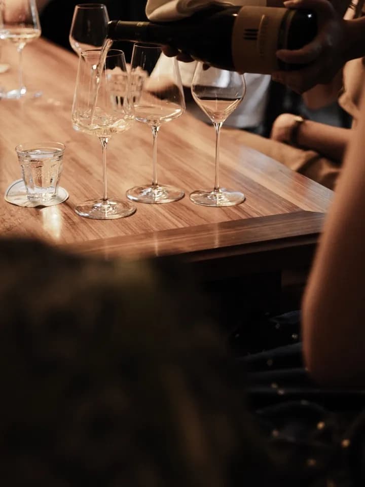 Weißwein wird bei einer Verkostung eingeschenkt